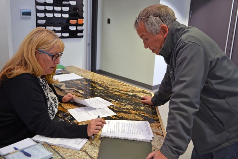 Heather Whymark, the town&#8217;s returning officer, serves Innisfailian David Toms who signed nomination papers Monday (Sept. 18) to run for town council.