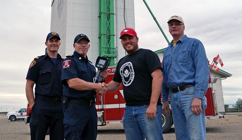 Gratitude for heroes at Niobe. From left to right is Innisfail Fire Department Capt. Jayme Hendrick; Gary Leith, fire chief of the department; Ryan Dodd, Canadian elevator