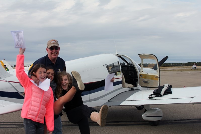 Pilot John Mulder stands beside the Cherokee 160 along with three thrilled students &#8211; Tasia Corcoran, Mya Van Vlaanderen and Gabrielle Seweryn &#8211; from Spruce View