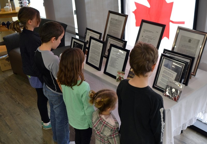 Children take a look at the special display at the Penhold &#038; District Library that features the First World War record of Lance-Cpl. Leo Baxter, the grandfather of