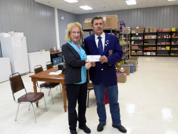 Dan Urban, a member of the Gwendale Elks Club, gives Brenda Hand, co-ordinator at the Innisfail and District Food Bank, a $1,000 cheque to support the agency&#8217;s effort