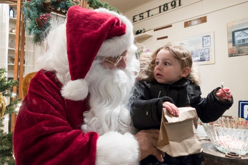 Nicole Wall visits with Santa Claus during Christmas festivities at the Innisfail Historical Village on Dec. 2.