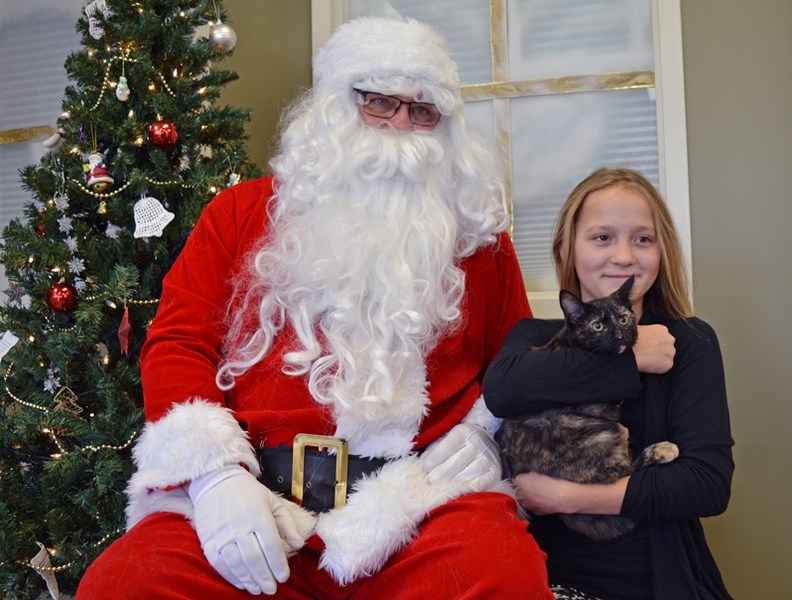 Taylor Peitzsche and her cat Sailor pose for a photo with Santa during the annual Pet Pictures with Santa at Poplar Grove Veterinary Services on Dec. 2.