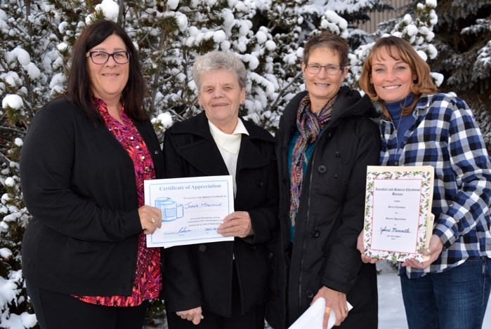 Cathy Ouellette, human resources manager at Johns Manville, far left, and Heather Cooper, plant administrator, far right, recently presented Carol Sim, left centre,