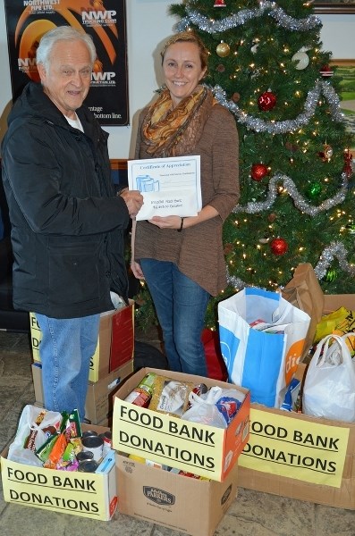 Dave Hample, a volunteer with the Innisfail and District Food Bank ( left), picked up a cheque for $2, 243 and several bags and boxes of food that was donated by NWP