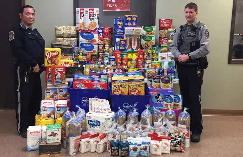 Penhold community peace officers Victor Tam, left, and Jay Klause, collected about 1,000 pounds of food during the Food For Fines campaign in December. Food and other items