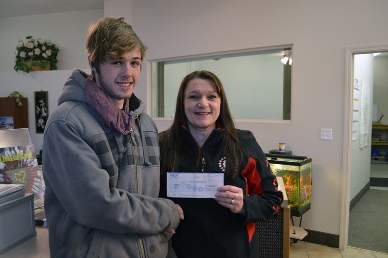 Ryan Groves accepts a cheque of $2,960 from Innisfail Kinettes member Darlene Thompson. The money is a scholarship fund that was created when Groves was born in Innisfail on