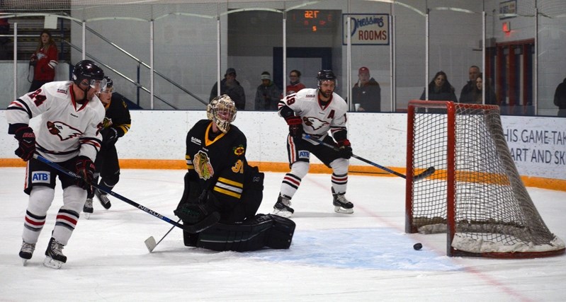 Eagles forwards Greg Moore, left, and Tyler Beechey watch as the puck crosses the goal line for Innisfail&#8217;s third goal of the game against the Fort Saskatchewan Chiefs