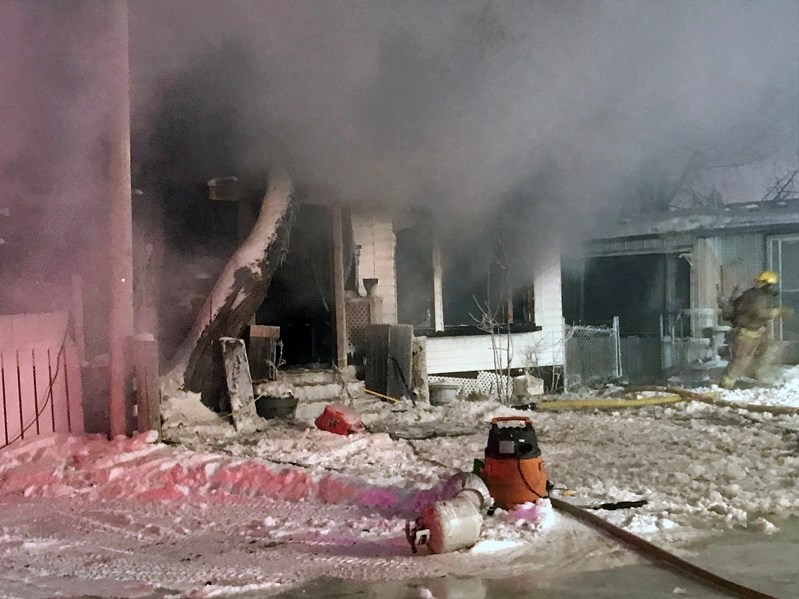 Smoke pours out of a fire-ravaged home at Penhold Estates Mobile Home Park during the early evening hours of Feb. 12. Two mobile homes were ultimately destroyed by the blaze.