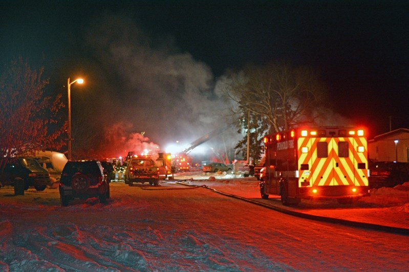 A chaotic scene early in the evening of Feb. 12 as Penhold and Innisfail firefighters battle a blaze in Penhold Estates Mobile Home Park. The fire destroyed two homes and