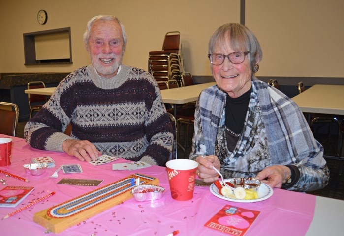 Innisfail residents Stuart Little, left, and his wife Grace enjoy a game of cards and some Valentine&#8217;s treats during the Welcoming Communities Valentine&#8217;s Tea