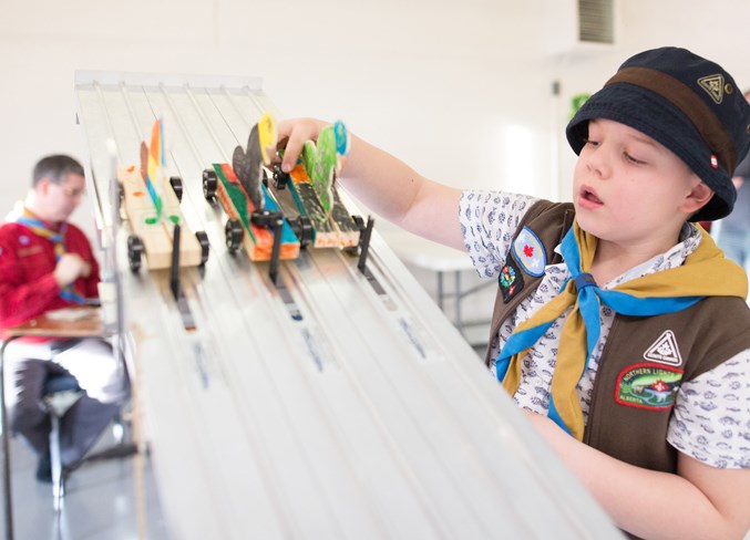 Beaver Scout Bryson MacPherson places his car on the racetrack.