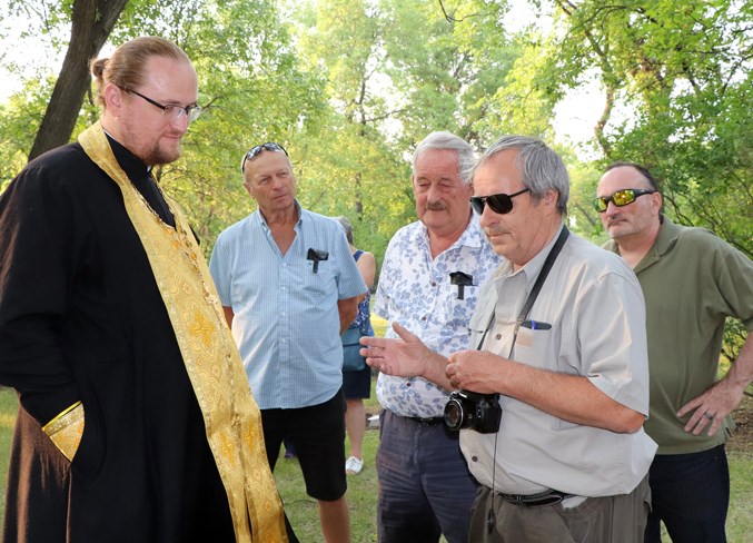  Brian Lesko, the family genealogist, (with camera), chats with Father Roman Pavlov following the service.