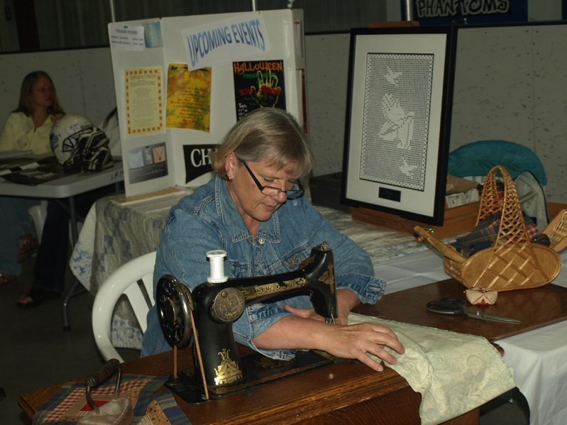 Anna Lentern, vice president of the Innisfail and District Hisotrical Village, demonstrates stiching using an antique sewing machine, estimated to be more than 100-years-old.