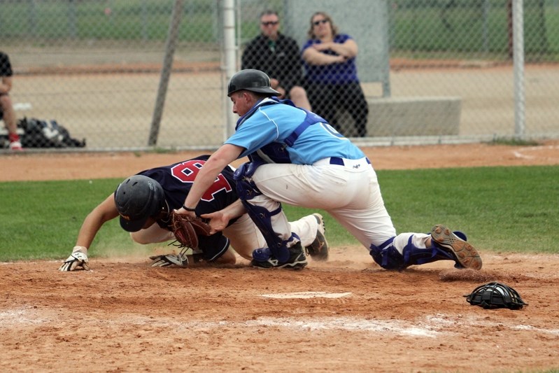 Innisfail Merchants catcher Tristan Cunningham tags out an Arm River player at the plate in the top of the seventh on a throw from right fielder Blair Mulder.