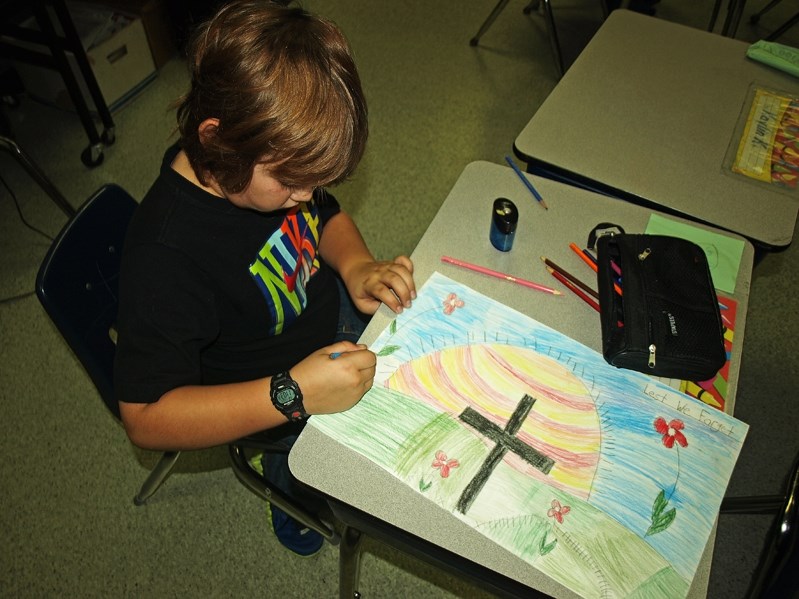 Dylan Pike, a Grade 3 student at John Wilson Elementary School, works on his poster for the contest.