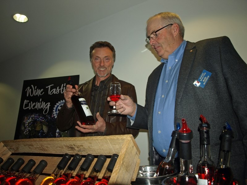 Rod Bradshaw, president of the Rotary Club of Innisfail, samples some wine from Strathmore&#8217;s Marvin Gill, proprietor of Field Stone Fruit Wines, at the Annual Wine