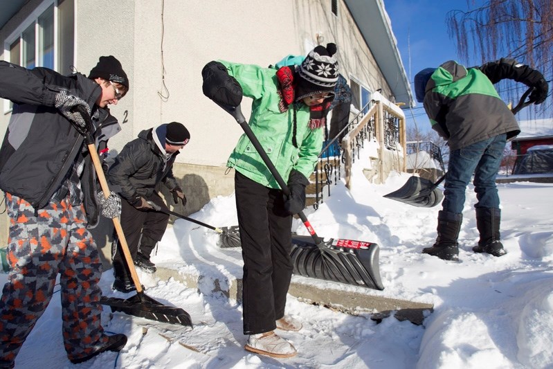 Snow Angels, left to right, Justin Wheaton, teacher Steve Jackson, Cheyenne Smallboy and Noah Barclay clear the pathway of a home in Innisfail on Dec. 4.