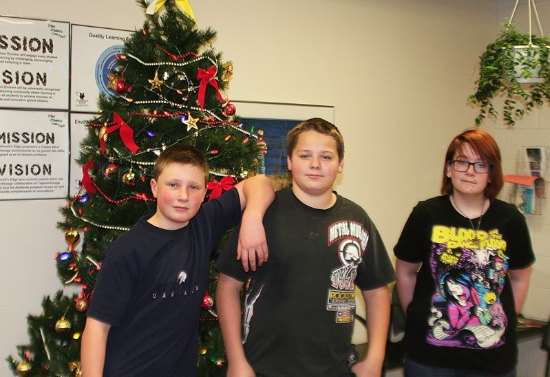 Innisifail Jr/Sr High students (left to right) Daktota Neilly, Phoenix Baird, and Lenore Oddy pose in front of the school christmas tree after sharing their favourite