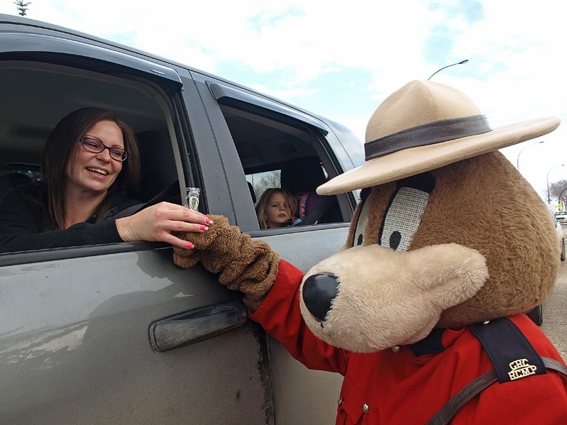 Katrina Mertick receives a candy cane from the Safety Bear during the RCMP&#8217;s annual Charity Check Stop on Dec. 14.