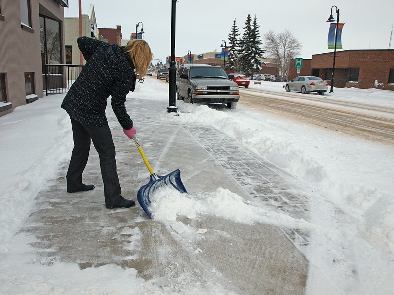 Downtown businesses were out early Monday morning clearing away the snow that fell heavily over the weekend.