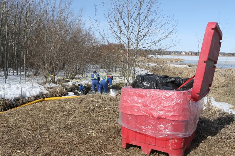 Innisfail town workers lay down absorbent pads onsite on the North East corner of Dodds Lake where a hydrocarbon spill was reported on April 11.