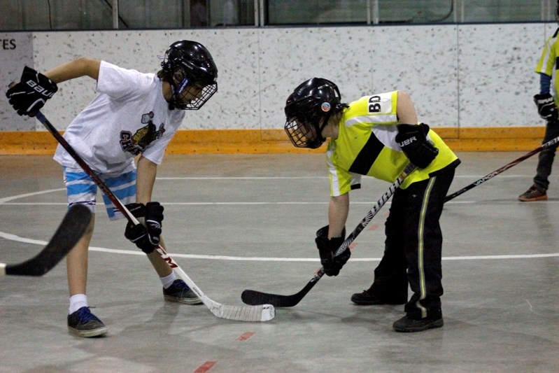 Young road hockey players faceoff at the 19th Dean Turnquist Road Hockey Tournament held on May 3 at the Innisfail Arena.