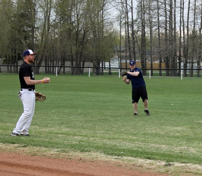 Andrew Bursteon (left) and Steve Boutellier of the Innisfail Indians warm up during their May 14 practice. Their first game will be held on May 21 at the home diamond.