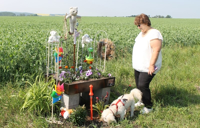 Amy Sorensen and Trystan Sorensen&#8217;s therapy dog, Cassie, pay a visit to the roadside monument to Trystan&#8217;s memory.