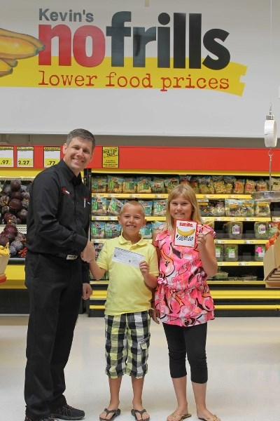 Kevin Meyer, owner of Kevin&#8217;s noFrills presents Piet and Mary-Lynn Dijkstra, members of Big Brothers and Big Sisters of Innisfail with $1,000 raised by Innisfail