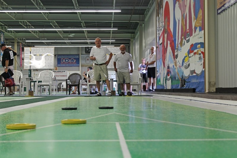 Frank Stokowski (left) and tournament organizer Brian Scott play an end of court shuffleboard during the weeklong western Canadian tournament on Aug. 13 at the Innisfail