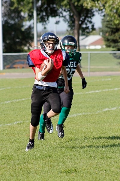 A defensive player runs with the ball during True Grit during their day of football.