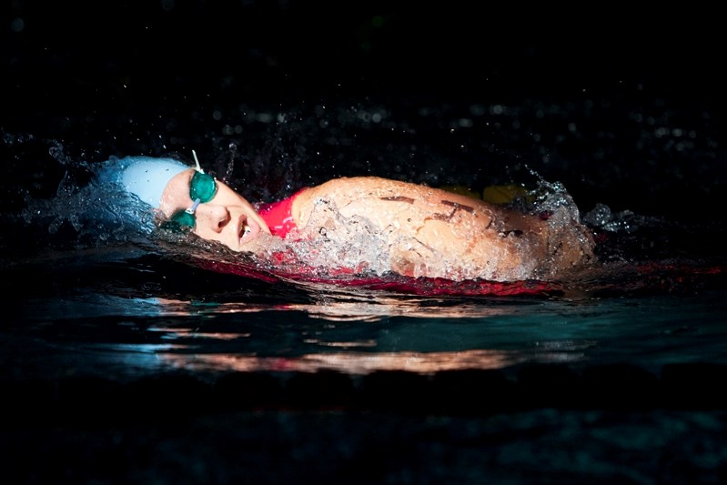 A triathlete swims under a ceiling light during an previous Innisfail Triathlon at the Innisfail Aquatic Centre.