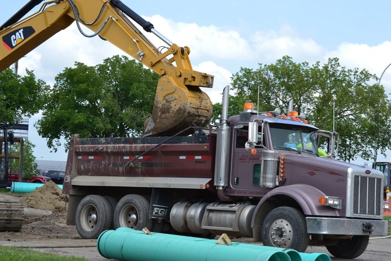 Machines dump the unwanted extracts from mainstreet into the back of a truck to get taken away.