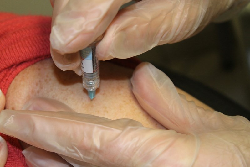 Innisfailian June Dubois receives her flu shot from Pharmasave&#8217;s Jeff Ertl on Oct. 21.