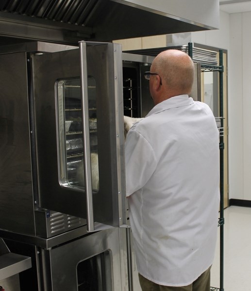 Chef Cliff Oak checks food for the parent-teacher interviews night on Oct. 22 at the new Penhold Crossing Secondary School.