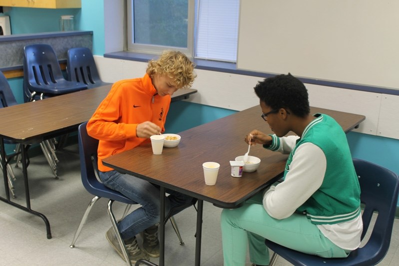 Innisfail High School students Luke Van Asselt (right) and Tanya Block eat breakfast during the school program in Brianne Fletcher&#8217;s home economics classroom on Oct. 23.