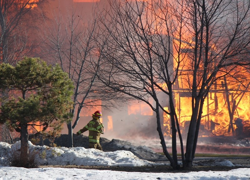 A Penhold firefighter walks the outskirts of the flames at the April 10 Wild Rose Manor fire which claimed the building in under an hour.