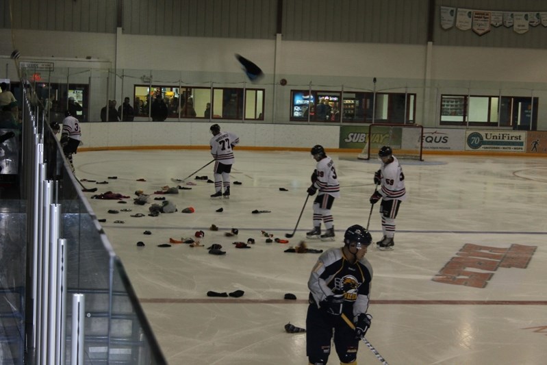 Innisfail Eagles and members of the Stony Plain Eagles pick up toques after the first Innisfail Christmas Bureau Toque Toss on Dec. 5.