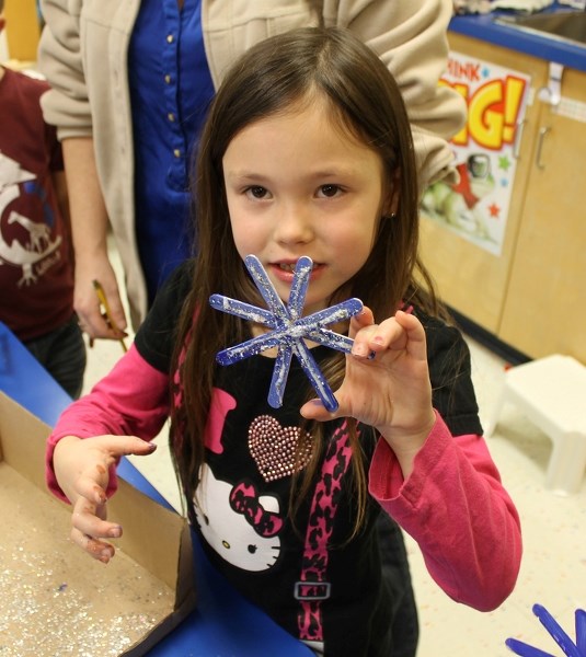 Five-year old Taytum Attwell of Chinook Center School shows off her purple sparkly snowflake created for the Hometown Christmas.