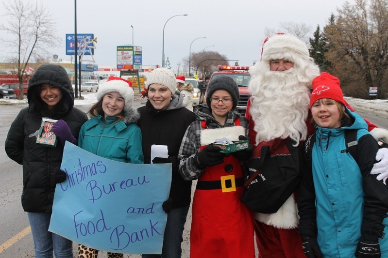 Santa Claus and his food bank/Christmas Bureau elves pose together during the Charity Check Stop on Dec. 13.