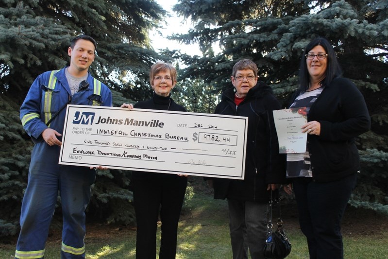 Lane Mottl (left) and Cathy Oullette (right) donate $9,782.44 to the Innisfail and District Christmas Bureau (second from left) and $1,949 to the food bank in addition to a