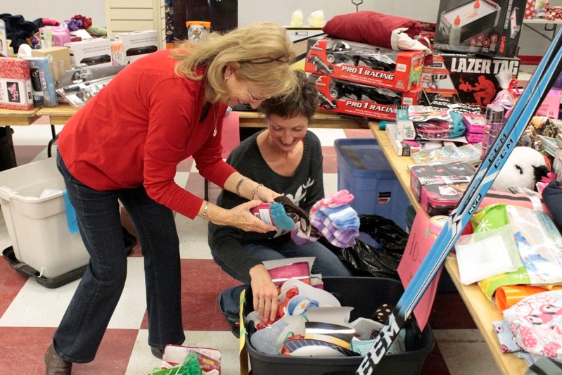 Karina Lucas (right) and an unidentified Christmas bureau volunteer pack a hamper for a family on the evening of Dec. 16.