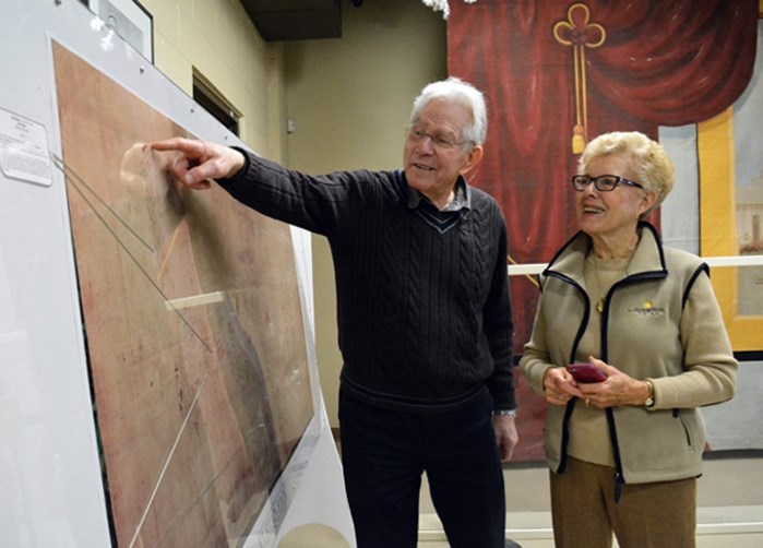 Stewart Ford of Penhold and Frances Cuyler of Edmonton look over the list of cast member names on the back of the Penhold curtain. Cuyler (nee Kenworthy) was one of several