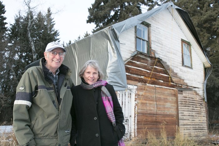 John MacDonald Thomson and Anna Lenters, president of the Innisfail and District Historical Society, at the pioneer log home of Isabella Sinclair. MacDonald Thomson is