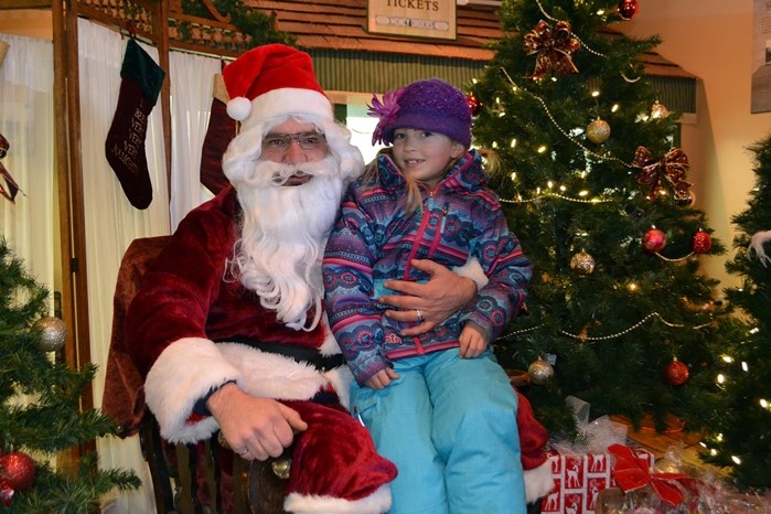 Seven-year-old Paige Van Sickle is thrilled to have a chance to meet Santa Claus inside the old Bowden train station during the Christmas at the Village event.