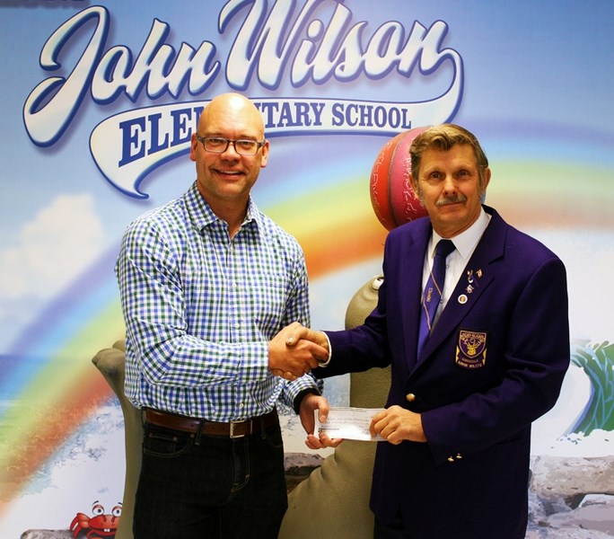 Jason Drent (left), principal at école John Wilson Elementary School, accepts a $2,000 donation from Dan Urban of the Gwendale Elks that will help purchase books for each