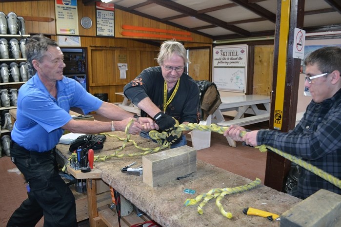 Volunteers from the Innisfail Ski Hill are hard at work on Jan. 7 repairing the tow rope that was vandalized on Jan. 6. From left to right is Bernie Vanderham, Darwin Ross