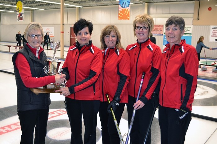 Joanne Daines (left), co-organizer of the Innisfail Ladies Bonspiel, hands the trophy to this year&#8217;s winning A Team for the 2016 Innisfail Ladies Bonspiel. From left to 