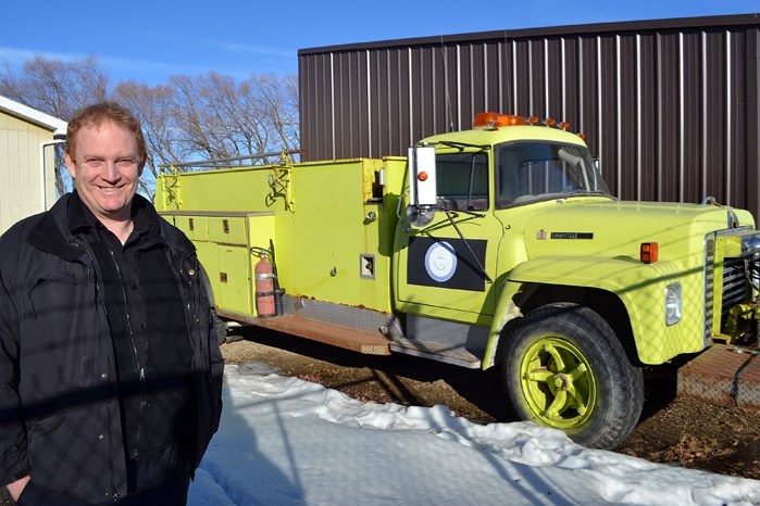 Innisfail fire Chief Dean Clark by the 1974 International fire truck, originally acquired and administered by the Innisfail Farm Fire Association and used by the town for